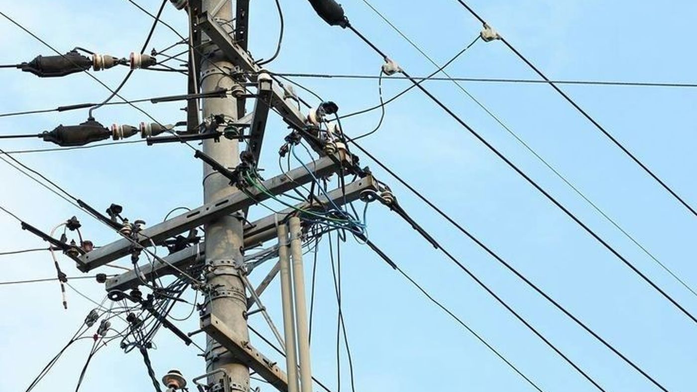 Poste de distribución eléctrica con transformador y líneas de alta tensión